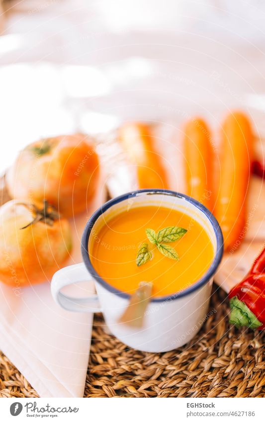 Vegane Kürbiscreme in einem emaillierten Becher mit Gemüse, Paprika, Lauch und Tomaten Suppe Lebensmittel Schalen & Schüsseln Mahlzeit Herbst Sahne orange