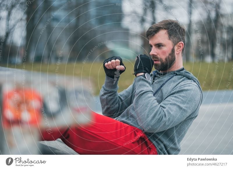 Junger Mann beim Sport in einer städtischen Umgebung Menschen kalte Witterung Herbst Sportler Stärke Motivation Tatkraft eine Person Bodybuilding Energie
