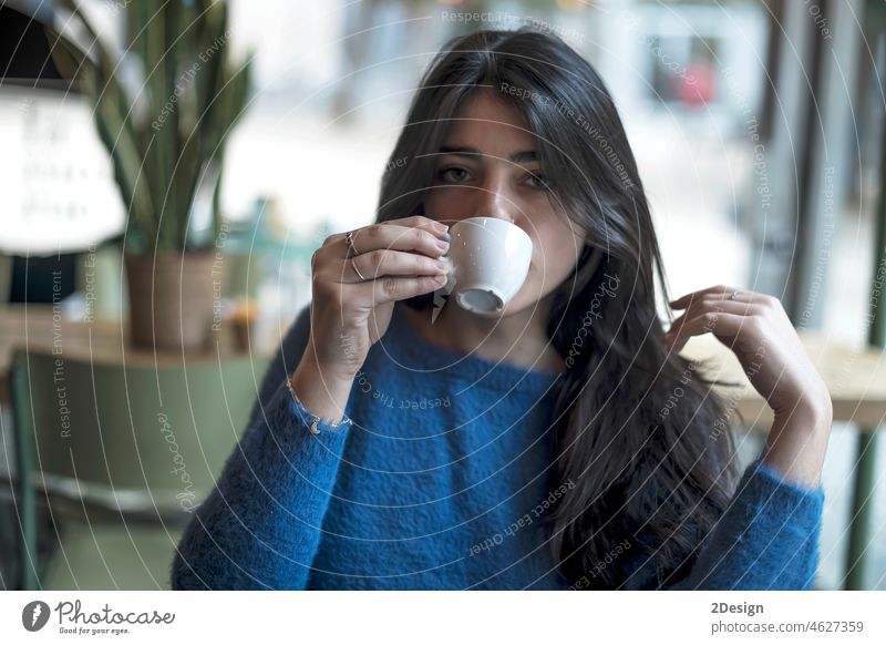 Junges Modell Blick Frau mit langen schwarzen Haaren sitzt in einem Café während der Brunch brünett Kunde Kaffee Beteiligung Kaffeetasse Freiberufler Hipster