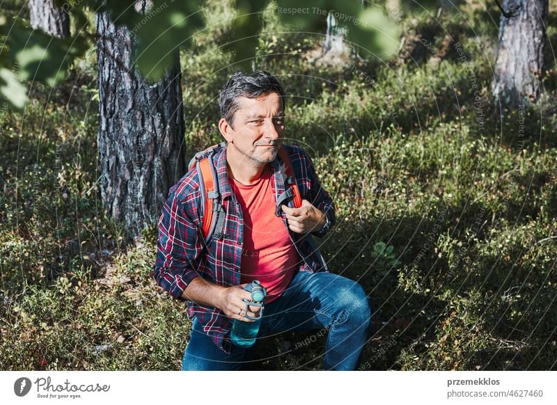 Mann mit Rucksack beim Wandern im Wald, der seinen Sommerurlaub aktiv in der Natur verbringt wandern Ausflug Trekking Reise laufen Erholung reisen Fernweh