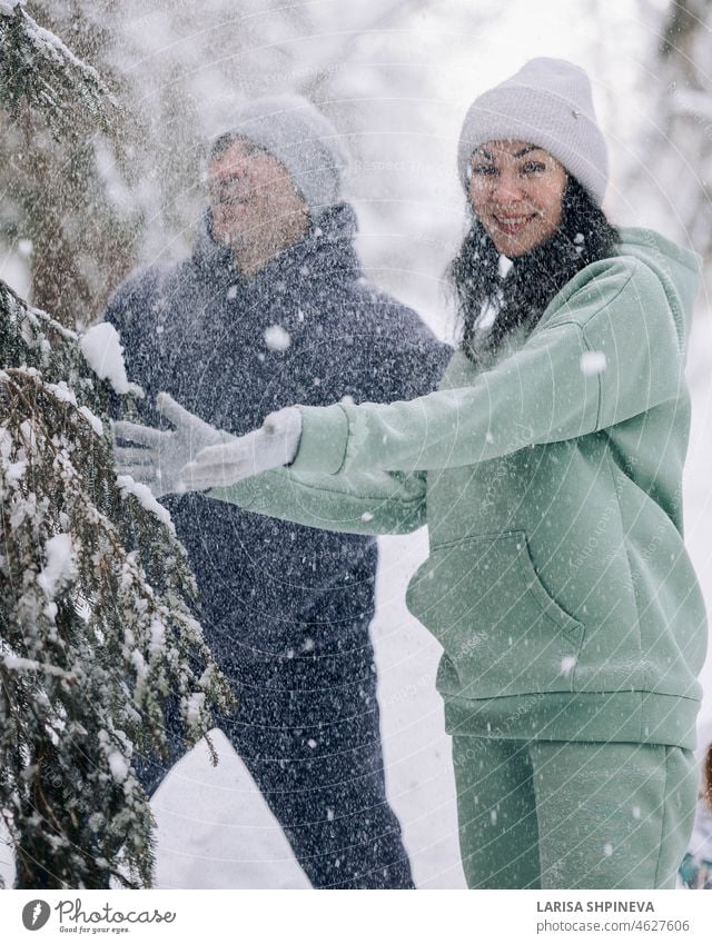 Glückliches Paar spielt Winterspiel im Wald im Freien. Liebe und Freizeit Konzept. Spiel Frau aktiv Erwachsener Ball schön brünett Kaukasier heiter Kleidung