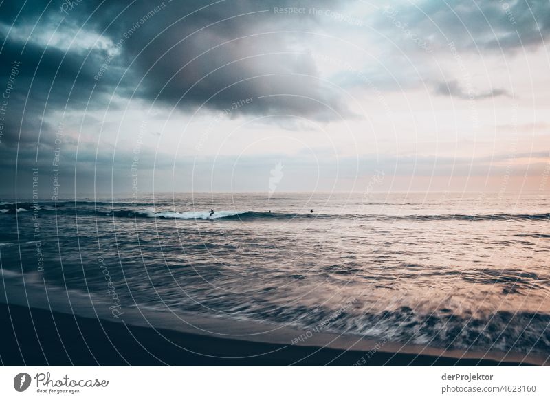 Wellen am Ufer und Surfer während des Sonnenuntergangs auf den Azoren Zentralperspektive Starke Tiefenschärfe Sonnenlicht Reflexion & Spiegelung Kontrast