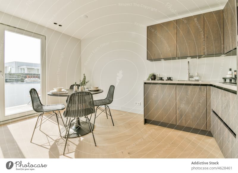 Interieur einer stilvollen Küche mit Möbeln Innenbereich Kabinett Tisch Stuhl geräumig heimwärts modern Stil Design wohnbedingt Appartement Tür Tageslicht