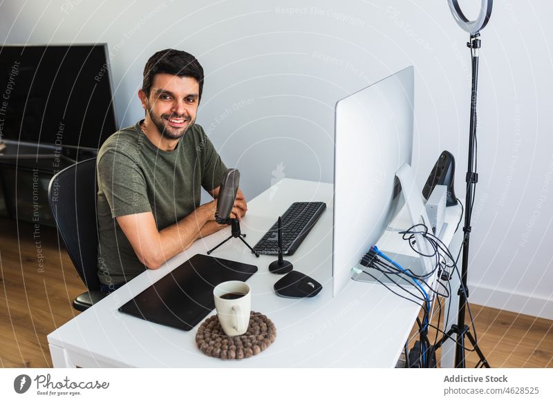 Positivgestalter am Tisch mit Computer und Mikrofon Mann Designer online Arbeit Büro Projekt Arbeitsplatz freiberuflich Apparatur Beruf Gerät Internet Job
