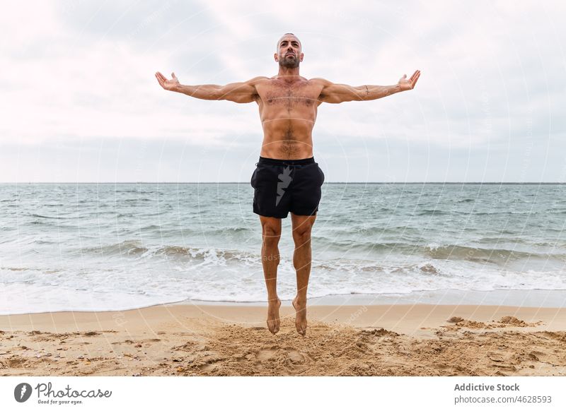 Sportler ohne Hemd springt am Sandstrand Mann nackter Torso MEER Training Ufer Gesunder Lebensstil Übung springen üben sportlich Wohlbefinden muskulös männlich