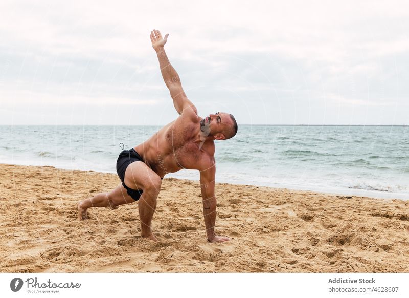 Shirtless Mann tun Seite Winkel asana am Strand Seitenwinkel parshvakonasana Yoga Asana nackter Torso MEER Training Ufer Gesunder Lebensstil Übung üben