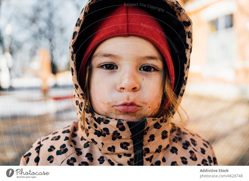 Kleines Mädchen mit schmutzigem Mund am Wintertag Kind Straße Großstadt Kindheit kindisch kalt Oberbekleidung essen dreckig Saison warme Kleidung Winterzeit