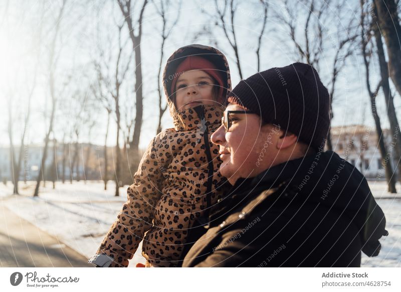 Vater trägt Tochter an einem Wintertag Vaterschaft Park Kind Straße Kindheit Schnee Zeitvertreib Großstadt kalt Oberbekleidung Saison warme Kleidung Winterzeit