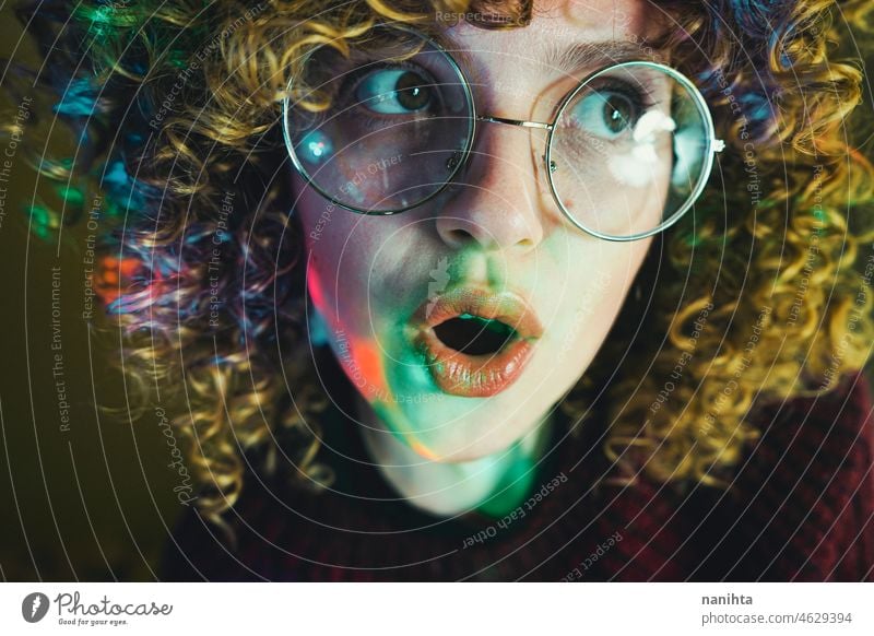 Porträt einer jungen Frau, beleuchtet von psychedelischen Lichtern retro neonfarbig Party lockig Behaarung Nacht Pub allein einsam Gesicht proyector Kunst