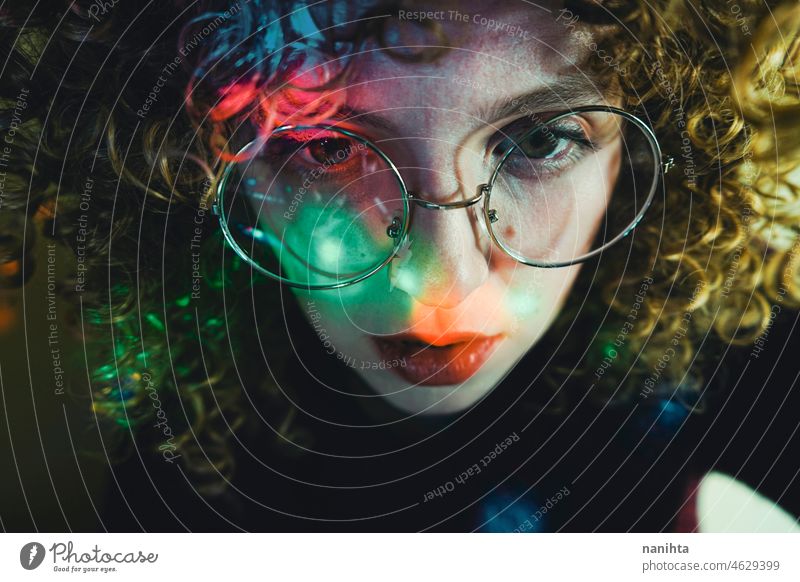 Porträt einer jungen Frau, beleuchtet von psychedelischen Lichtern retro neonfarbig Party lockig Behaarung Nacht Pub allein einsam Gesicht proyector Kunst