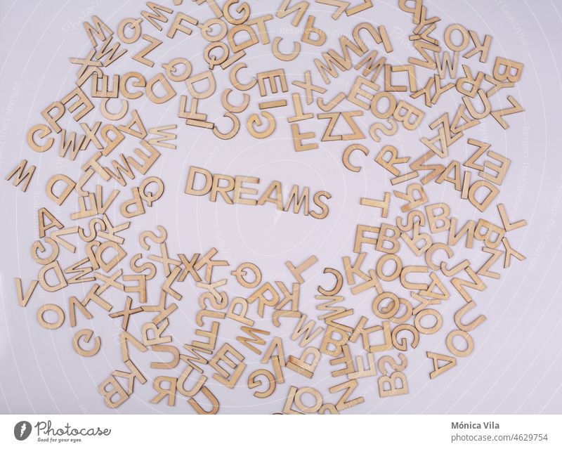 eine Menge Holzbuchstaben und das Wort Träume Briefe Wortschatz Alphabet schwarz weiß Hintergrund Wörter nachhaltig Spielzeug Lernspielzeug kreisen