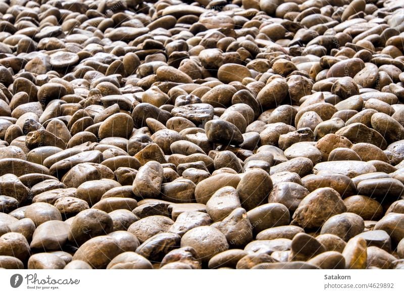 Textur des Flusssteins im Gehweg Stein Straßenbelag Material Laufsteg Kopfsteinpflaster Hintergrund natürlich Felsen rau Muster im Freien Kieselsteine Design