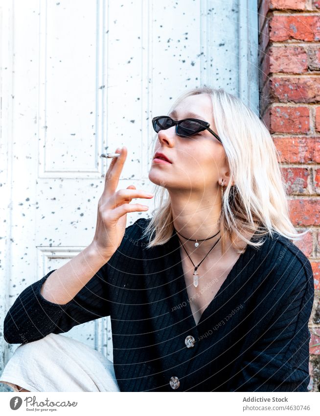 Frau raucht in der Nähe eines schäbigen Gebäudes Rauch Zigarette auflehnen Süchtige Nikotin Habitus Straße Tabak ungesund verwittert trendy attraktiv Großstadt