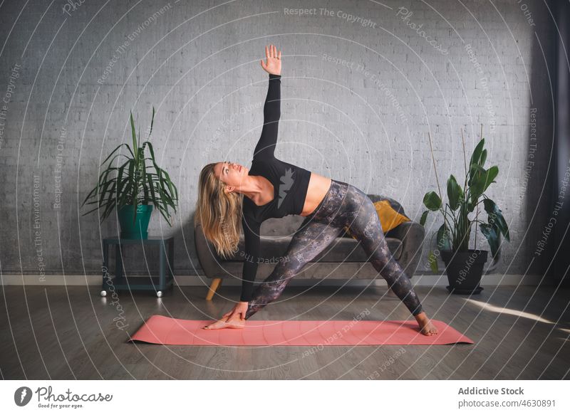 Schlanke Frau in Dreieckspose übt Yoga Triangel-Pose Übung Geist Training mental Gesunder Lebensstil sportlich Aktivität trikonasana Körperhaltung Wellness