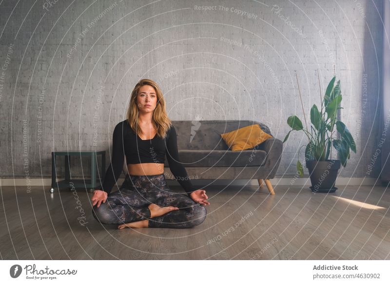 Frau meditiert auf Yogamatte mental meditieren Körperhaltung Atem üben Mudra Energie gestikulieren Stressabbau Erholung Augen geschlossen positionieren