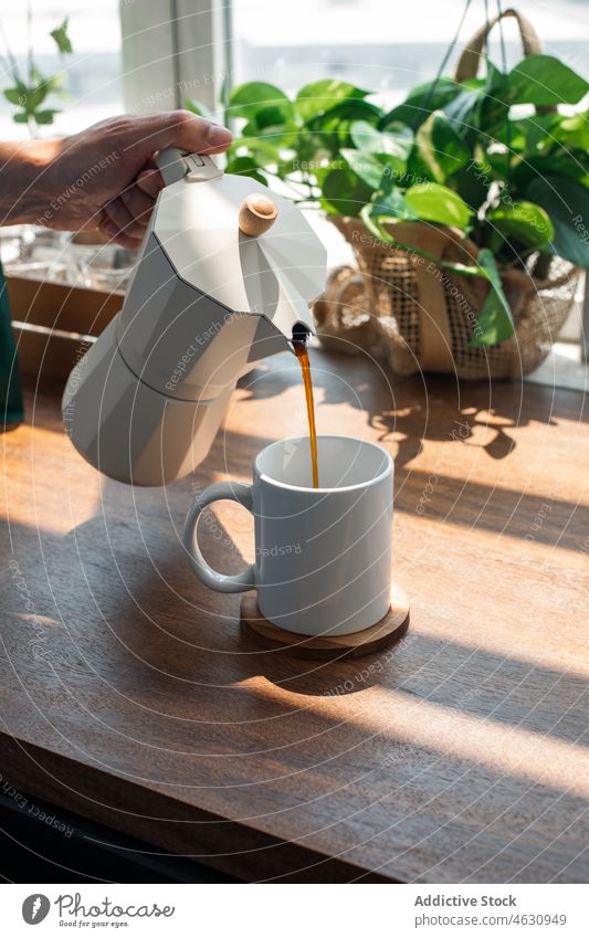 Anonyme Person gießt Kaffee aus einer Moka-Kanne ein eingießen Moka-Topf Koffein Getränk Heißgetränk Erfrischung Küche Morgen Tisch heimwärts geschmackvoll
