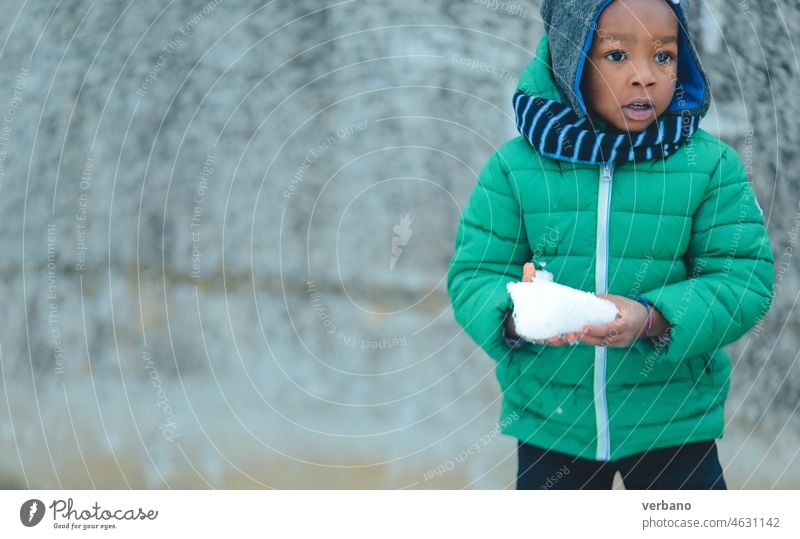 afrikanisches Kind spielt im Winter mit Schnee Afrikanisch Mädchen niedlich Glück kalt Junge Freizeit jung Spaß Person aktiv schwarz Kindheit spielen im Freien