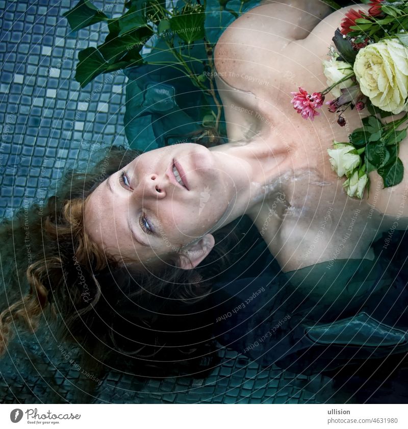 Porträt der jungen sexy unglücklich verrückte Frau Dame Ophelia mit roten Haaren liegt mit den Blumen mit toten Augen im Wasser im Pool, Kopie Raum ophelia
