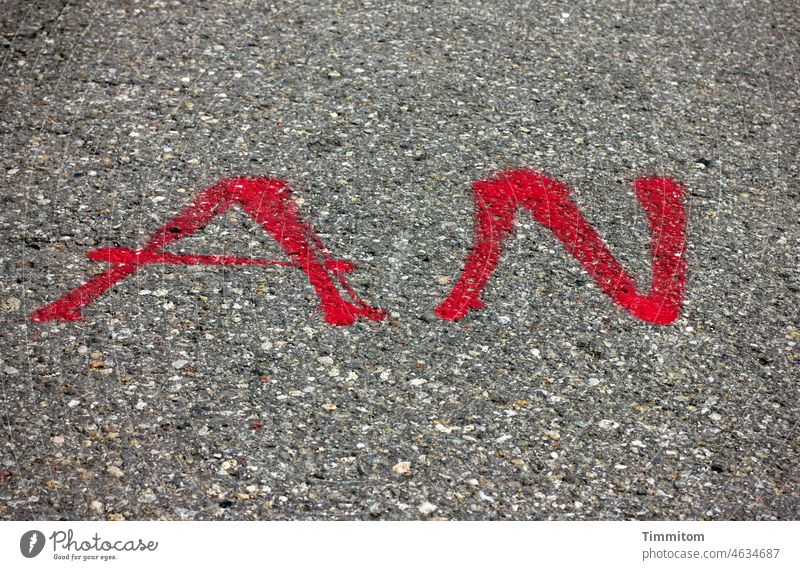 AN in rot An Wort Buchstaben Schriftzeichen Farbe Asphalt Straße Text grau nicht aus Menschenleer Hinweis Information