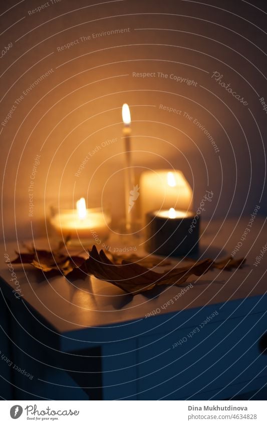 Rendezvous bei Kerzenschein - leuchtende Kerzen auf dem Nachttisch mit Herbstblättern als Dekoration romantisch Termin & Datum Romantik Winter warm gemütlich