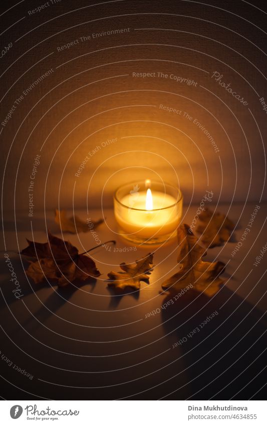 Kerzenschein auf dem Nachttisch mit Herbstblättern drum herum - gemütliche Stimmung zu Hause am Abend oder in der romantischen Nacht Flamme Feuer glühend Halt
