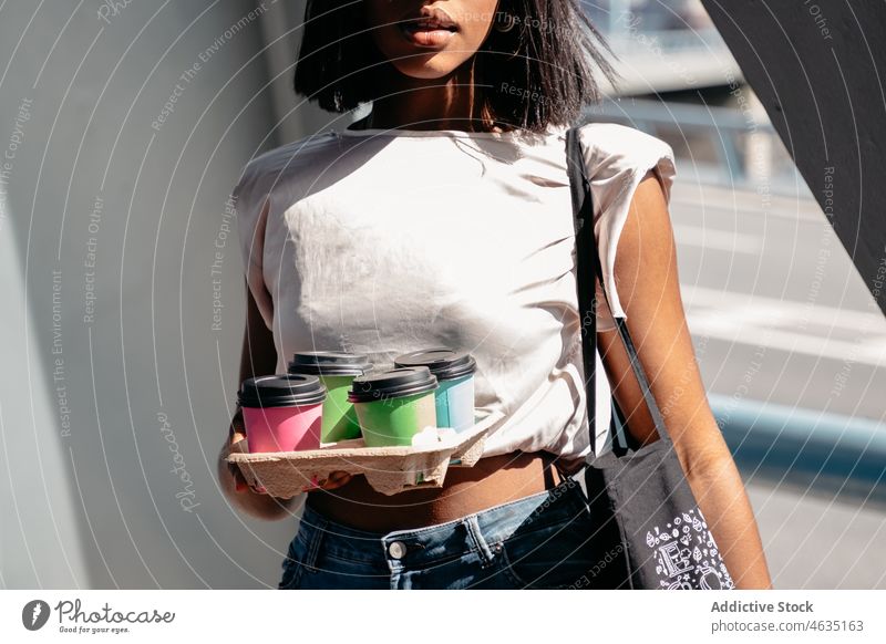 Crop Black Frau mit Getränken zum Mitnehmen Kaffee führen Straße urban Klammer modern tagsüber Großstadt schwarz Afroamerikaner ethnisch Stil Imbissbude