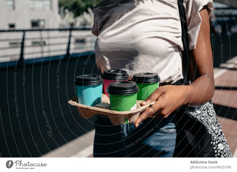 Schwarze Frau trägt Tablett mit Kaffee zum Mitnehmen Imbissbude Getränk Karton führen Orden Einwegartikel Kauf Käufer trinken Straße Tasse Schachtel Pappbecher