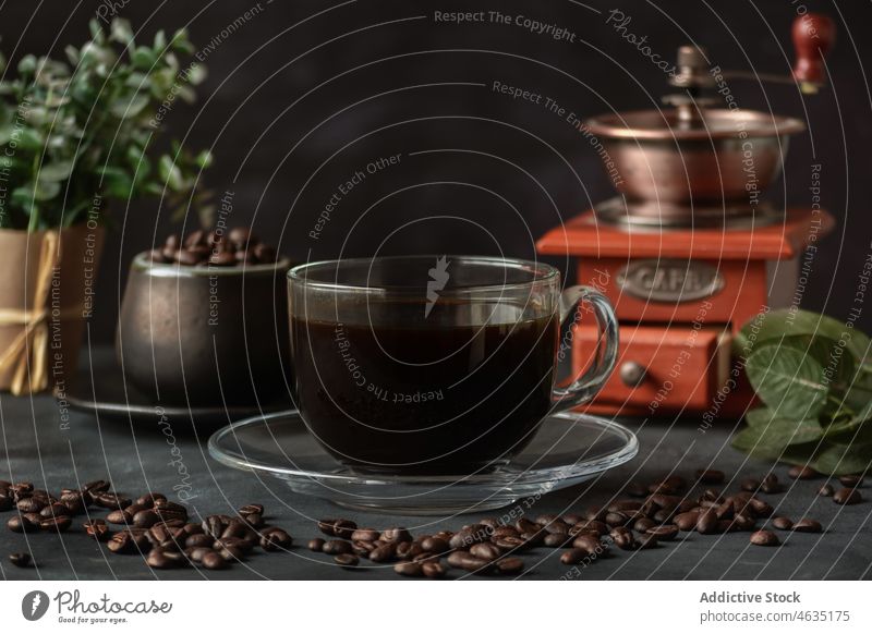 Glas Kaffee auf Tisch mit Bohnen und Handmühle aromatisch dienen Mühle Aroma manuell brauen frisch Koffein Geschmack Schleifmaschine Getränk trinken Tasse
