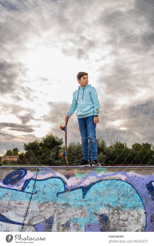 Niedlicher Teenager auf einem Skatepark gegen einen bewölkten Himmel Aktion Aktivität Jugendzeit sportlich fantastisch Holzplatte Boarding Junge lässig