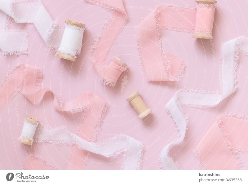 Romantische Szene mit rosa und weißen Seidenbändern auf hellrosa Ansicht von oben Bänder Draufsicht romantisch Valentinsgruß Valentinstag Hochzeit mädchenhaft