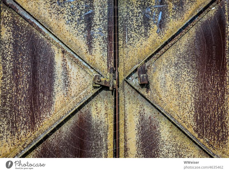 Eine große schwere verschlossene Eisentür in einer historischen Industrieanlage Tor Tür Geometrie rostig Diagonale Nahaufnahme Außenaufnahme draußen