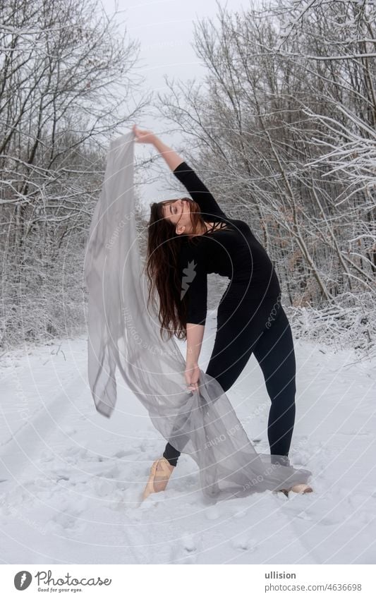 Junge Frau in schwarzem Ballettanzug spielt im verschneiten Wald mit einem hellen Tuch jung Tänzer Winter Balletttänzer Anmut Mädchen Leistung weiß