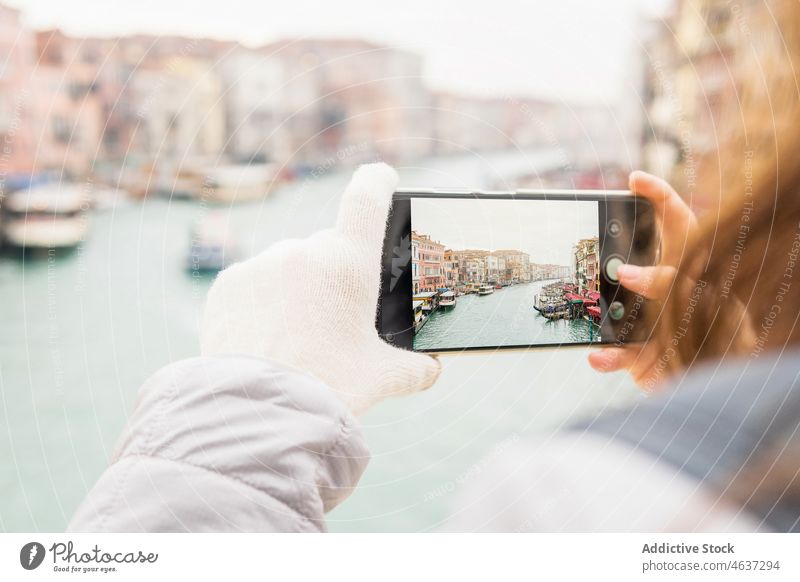 Unbekannte Frau fotografiert Kanal inmitten von bunten Gebäuden an einem bewölkten Tag in Venedig fotografieren Smartphone Architektur Urlaub Reisender Ausflug