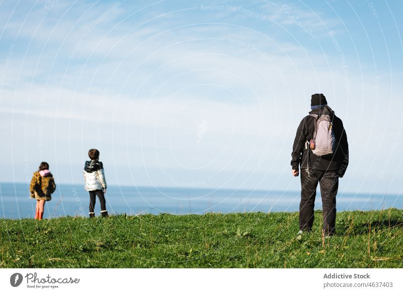 Großvater und Enkelkinder beobachten die Meereslandschaft vom Hügel aus Großeltern MEER Natur erkunden Zusammensein bewundern blau Aufmerksamkeit zeigen Enkelin