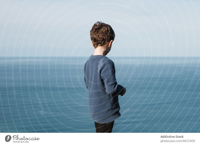 Junge bewundert das blaue Meer von der Küste aus MEER bewundern Freiheit Kind Meereslandschaft beobachten Natur nachdenken Rippeln Umwelt Kindheit stehen