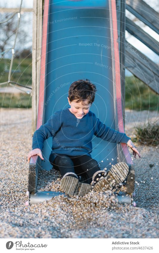 Niedlicher Junge rutscht auf Spielplatz Kind Sliden spielen Spaß haben unterhalten Kindheit Vergnügen spielerisch Sommer Zeitvertreib Freizeit Erholung ruhen