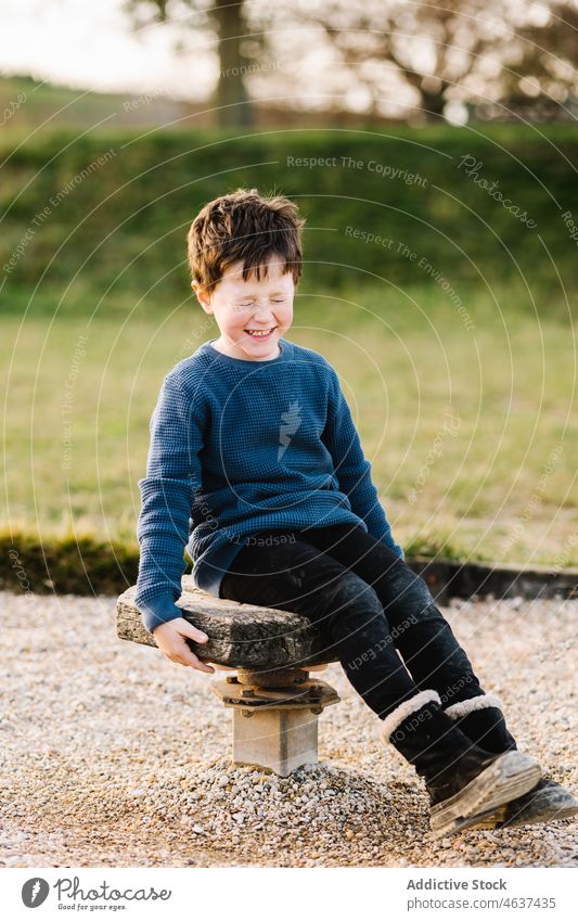 Fröhlicher Junge auf Holzplattform Kind Spielplatz spielen Spaß haben unterhalten Augen geschlossen Kindheit Vergnügen spielerisch Sommer Zeitvertreib Freizeit