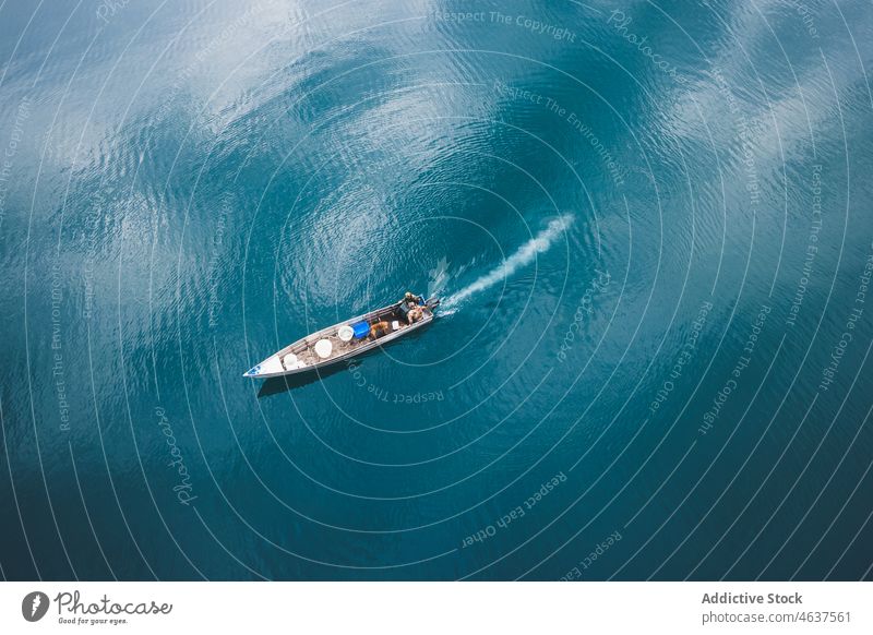 Motorboot schwimmt im blauen See Natur Wasser Schwimmer aqua Sommer Gefäße türkis Seeufer Windstille friedlich sich[Akk] bewegen Boot Gelassenheit Sonne Rippeln
