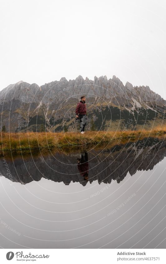 Mann bewundert Berge am See Natur Reisender Berge u. Gebirge Ufer Landschaft bewundern reisen Ausflug männlich Spaziergang Nebel malerisch