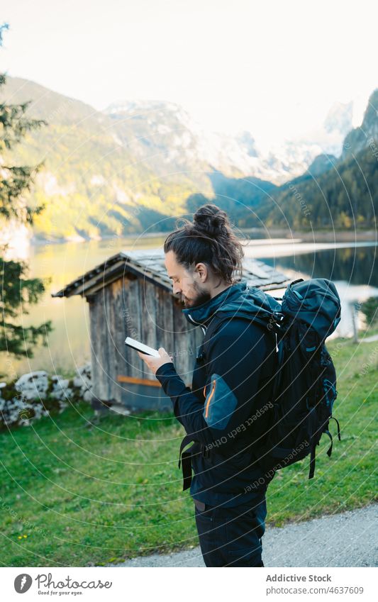 Reisender benutzt Smartphone in der Nähe eines Bergsees Mann Natur Berge u. Gebirge See benutzend reisen Backpacker Tourist Österreich männlich Mobile Ausflug