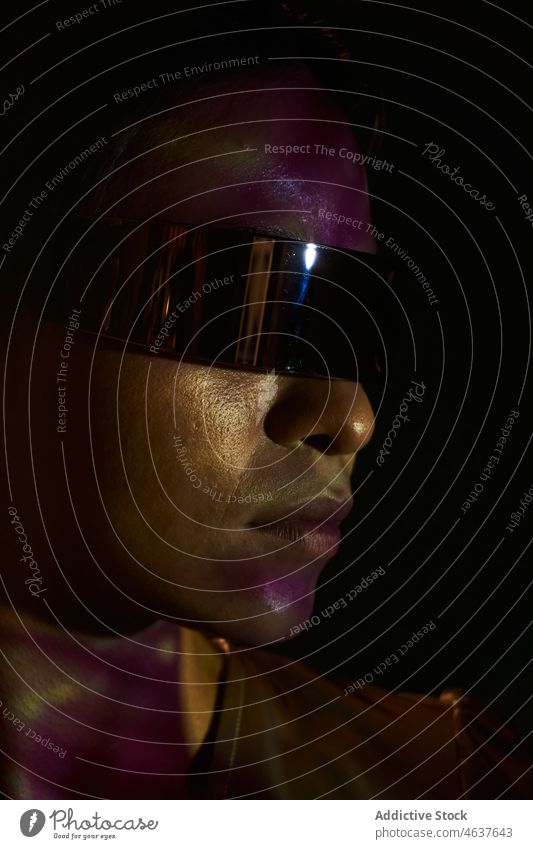Modische ethnische Dame in futuristischem Outfit steht im Studio Frau Stil selbstsicher Virtuelle Realität Model Porträt trendy Erfahrung selbstbewusst digital