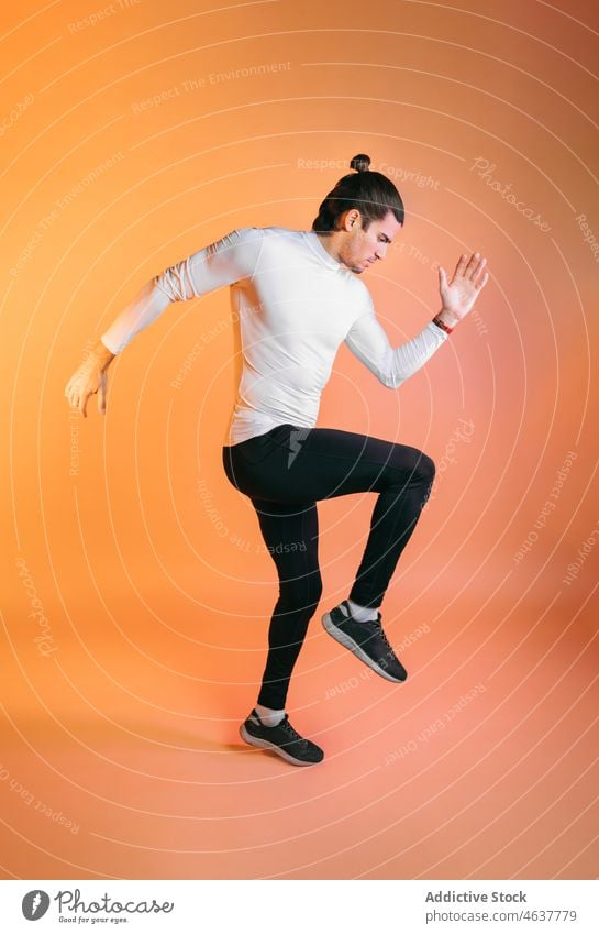 Entschlossener hispanischer Sportler läuft in orangefarbenem Studio laufen Training Aktivität Motivation Fitness Übung Wellness Bestimmen Sie Mann Wohlbefinden