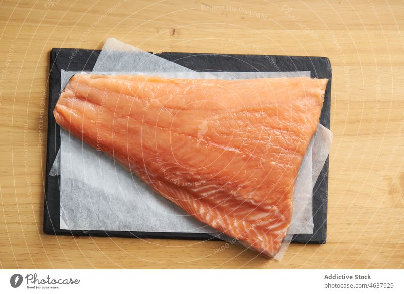 Roher Fisch auf einer Schiefertafel mit Zutaten Lachs roh Filet Lebensmittel Bestandteil Küche Koch kulinarisch Gewürz Rezept Meeresfrüchte vorbereiten