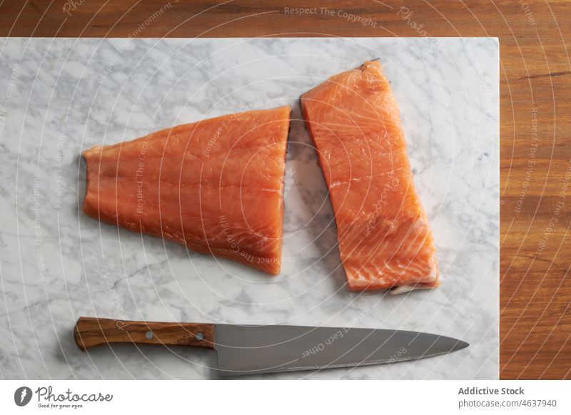 Roher Fisch auf einem Marmorbrett zum Schneiden Lachs roh Filet Lebensmittel Bestandteil Küche Koch kulinarisch Messer Gewürz Schiefer geschnitten Murmel Rezept
