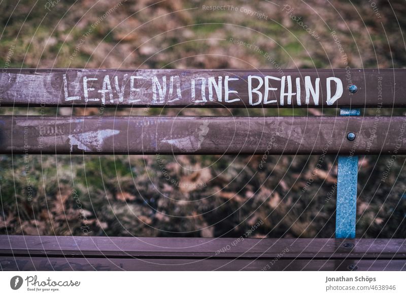 Leave no one behind – Schrift auf Parkbank soziale gerechtigkeit Gerechtigkeit lass niemanden zurück Refugees welcome Sitzbank Tag Refugees Welcome willkommen