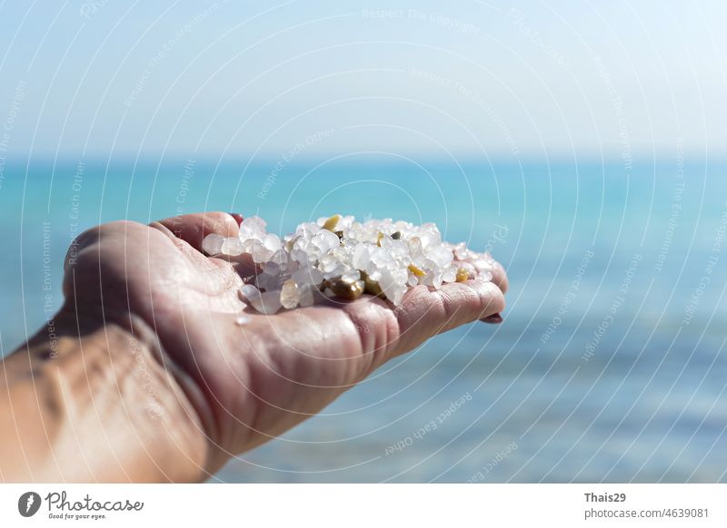 Meersalzkristalle in der Hand einer Frau, natürliche Mineralbildung am Toten Meer. Sie hält Meersalzkristalle in der Hand. Hände und weißes natürliches Kristallsalz. Eine Handvoll Salz