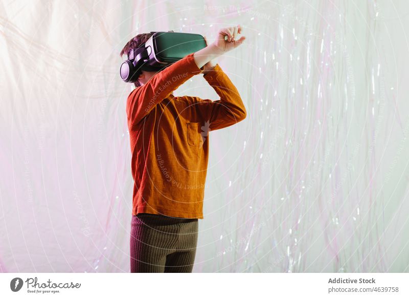 Glückliches Kind bei der Interaktion mit der virtuellen Realität im Studio Virtuelle Realität interagieren Junge Brille VR erkunden berühren aufgeregt Headset