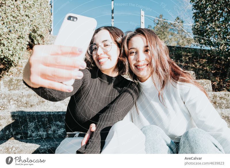 Mädchen, die ein Selfie machen, während sie auf einer Treppe sitzen, moderne Campus-Student Jugendliche, die ein Video für soziale Netzwerke aufnehmen, während sie lächeln. Gute Vibes und Glück Konzept. Afrikanische Mädchen an der Universität