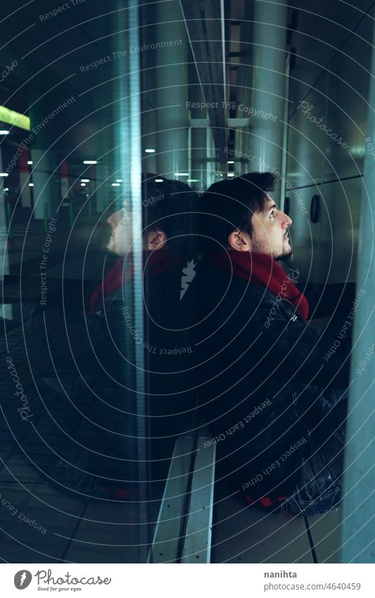 Junger Mann allein in einem Busbahnhof bei Nacht. Einsamkeit urban Station verirrt Depression traurig Traurigkeit gebrochen aufgelöst vergessen Stimmung blau