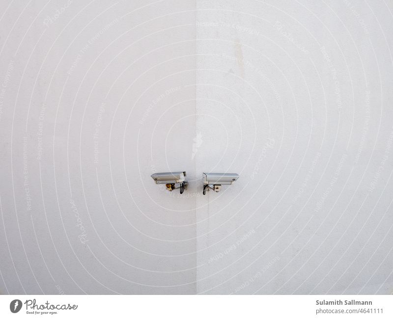Zwei Überwachungskameras an weißer Wand elektrogeräte fotografie hausecke Hauswand medien sehr wenige minimalistisch Schutz sicher Zauberstab überwachung